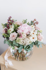 Wedding bouquet of white lilac, roses, peony and buttercup. Lots of greenery, modern asymmetrical disheveled bridal bunch. Spring flowers