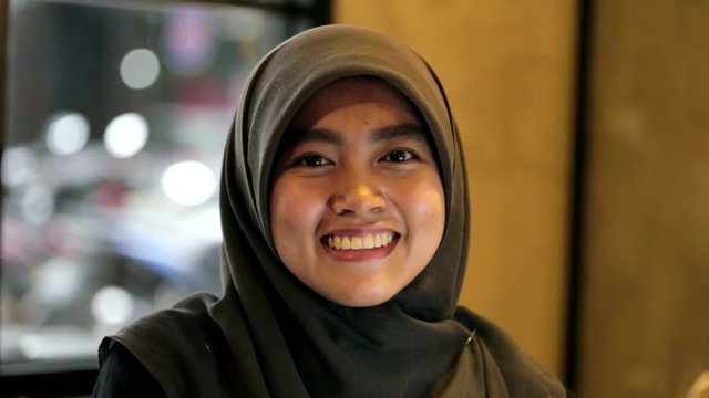 Portrait of muslim south east asian woman with hijab is smiling and playful