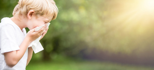 Kind mit Allergie beim Niesen in Taschentuch