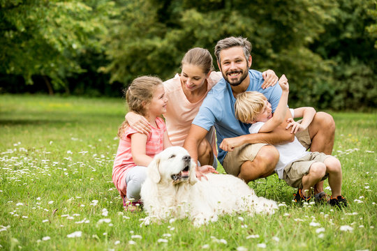 Glückliche Familie mit Kinder und Hund im Garten