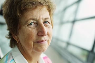 close up indoor portrait of 70 years old senior woman