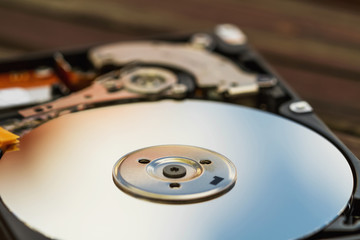 Open computer hard disk drive (HDD) with spindle and plate. Closeup, selective focus