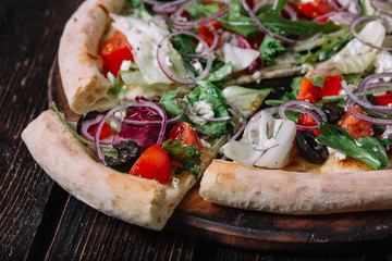 Sliced vegeterian pizza on wood background