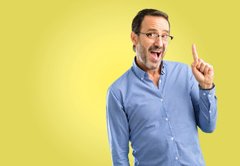 Handsome middle age man pointing away side with finger