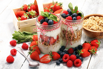 Glass jar of homemade granola with yogurt and fresh berries