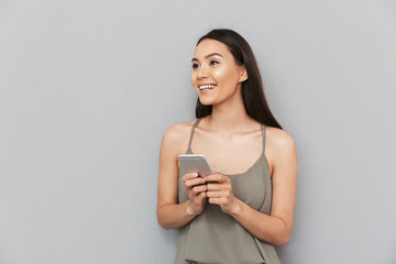 Portrait of a smiling asian woman holding mobile phone