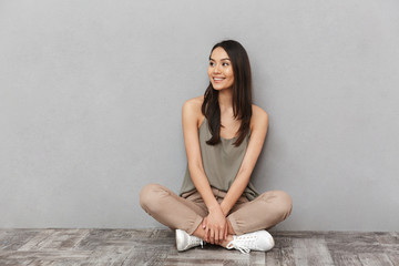 Portrait of a smiling asian woman sitting on a floor