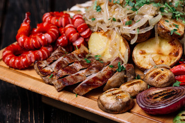 Assorted delicious grilled meat, sausages and vegetables on cutt