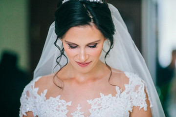 Naklejka premium Attractive bride with style wedding hairstyle. Bride looking down. Woman before wedding ceremony.