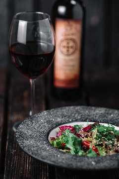 Salad with beef teriyaki served with Bottle and Glass of red win
