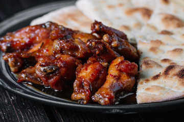 Juicy fried chicken wings with flatbread on wood backiground