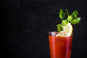 Fototapeta na wymiar Bloody Mary cocktail in glass on black background. Copyspace
