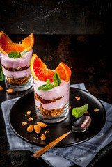 Healthy breakfast, Blood Orange Parfait with granola. yogurt, almond and mint, dark rusty background, copy space