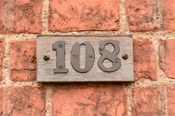 House number 108 sign on wall