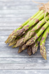 Bunch of fresh asparagus on wooden table.