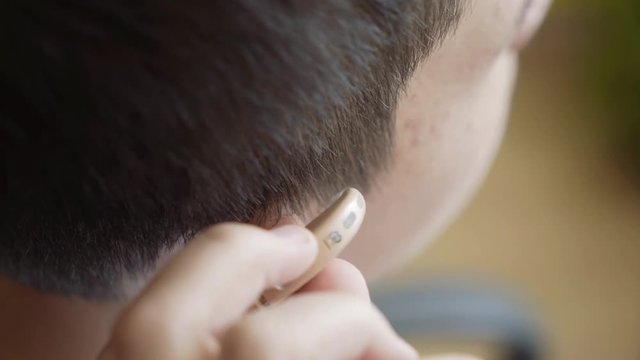 The guy removes the hearing aid. Man with hearing aid