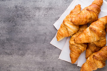 Tasty buttery croissants on old graye table.