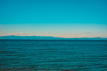 vintage colored picture of sea with mountains in the background