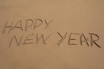 Fototapeta na wymiar Das Wort Happy New Year in den Sand geschrieben