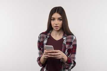 Social networks. Nice pleasant woman holding her smartphone while chatting in social networks