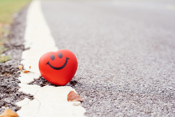 Fototapeta premium Smile red heart beside road,health, medicine and charity concept.