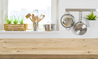 Wooden table top on blurred kitchen interior with copy space