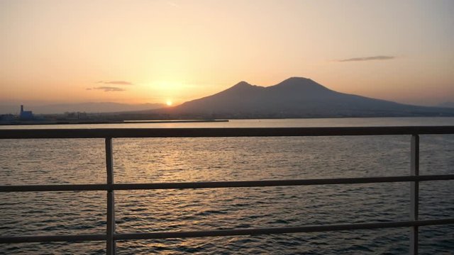 sunrise in the Gulf of Naples with Vesuvius in the background seen from the deck of the ship that enters the port