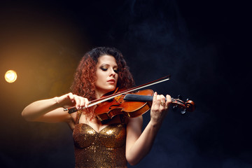 Violinist girl performs on stage.