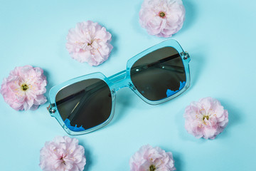 blue sunglasses with rose flowers on a blue background