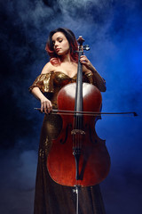 Fototapeta na wymiar The cellist girl performs on stage.