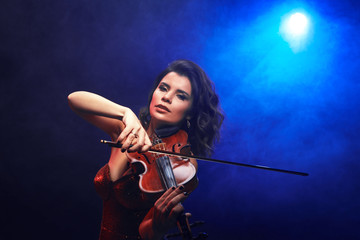 Fototapeta na wymiar Violinist girl performs on stage.