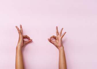 The human hands raise up on pink pastel background,show OK hand sign,with clopping path,symbol of...