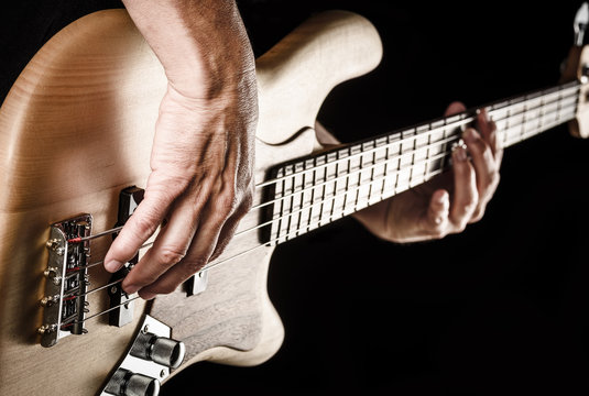 hands of rock bassist playing bass
