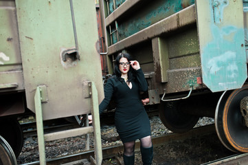 Fototapeta na wymiar Brunette girl wear in black with glasses in railway station.