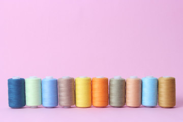 sewing thread of different colors on a colored background.
