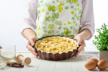 Chef preparing apple pie on a white background