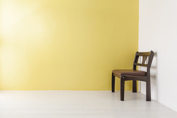 classic wooden chair on yellow wall