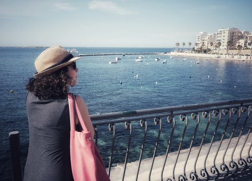 girl looks at panorama of bugibba in malta