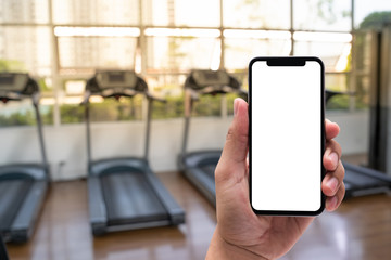 Young man Hand holding smartphone in gym to  fitness phone fitness exercise concept