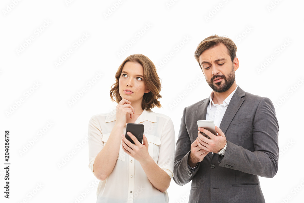 Poster Portrait of a pensive business couple holding mobile phones