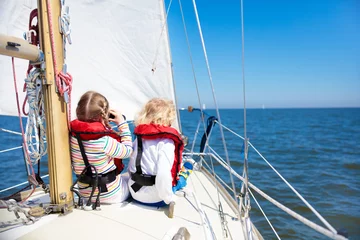 Küchenrückwand glas motiv Kids sail on yacht in sea. Child sailing on boat. © famveldman