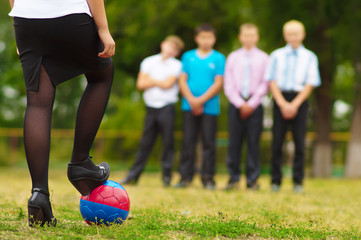 girl preparing to score a goal for four guys