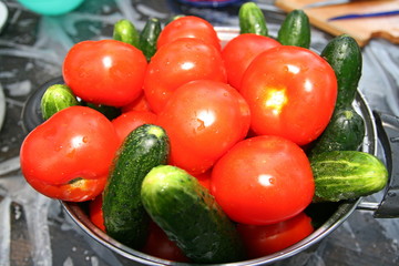 Tomatoes and cucumbers in a metal pan.