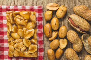 Candy with peanut: Pe de Moleque in Brazil and Chikki in India. Sweet food of Festa Junina, a typical brazilian party. Snack over red plaid fabric.