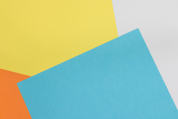 Colorful paper background on top view . (blue, white, yellow, orange)