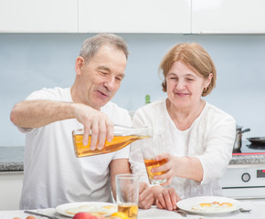 Obraz na płótnie Canvas elderly couple having breakfast in the kitchen