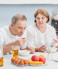 elderly couple eating in the kitchen