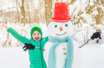 Joyful boy with snowman