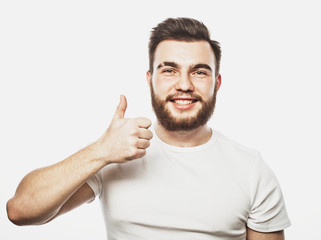 Portrait of a cheerful young bearded man showing okay gesture isolated on the white background