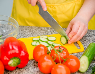 female hands cut a cucumber